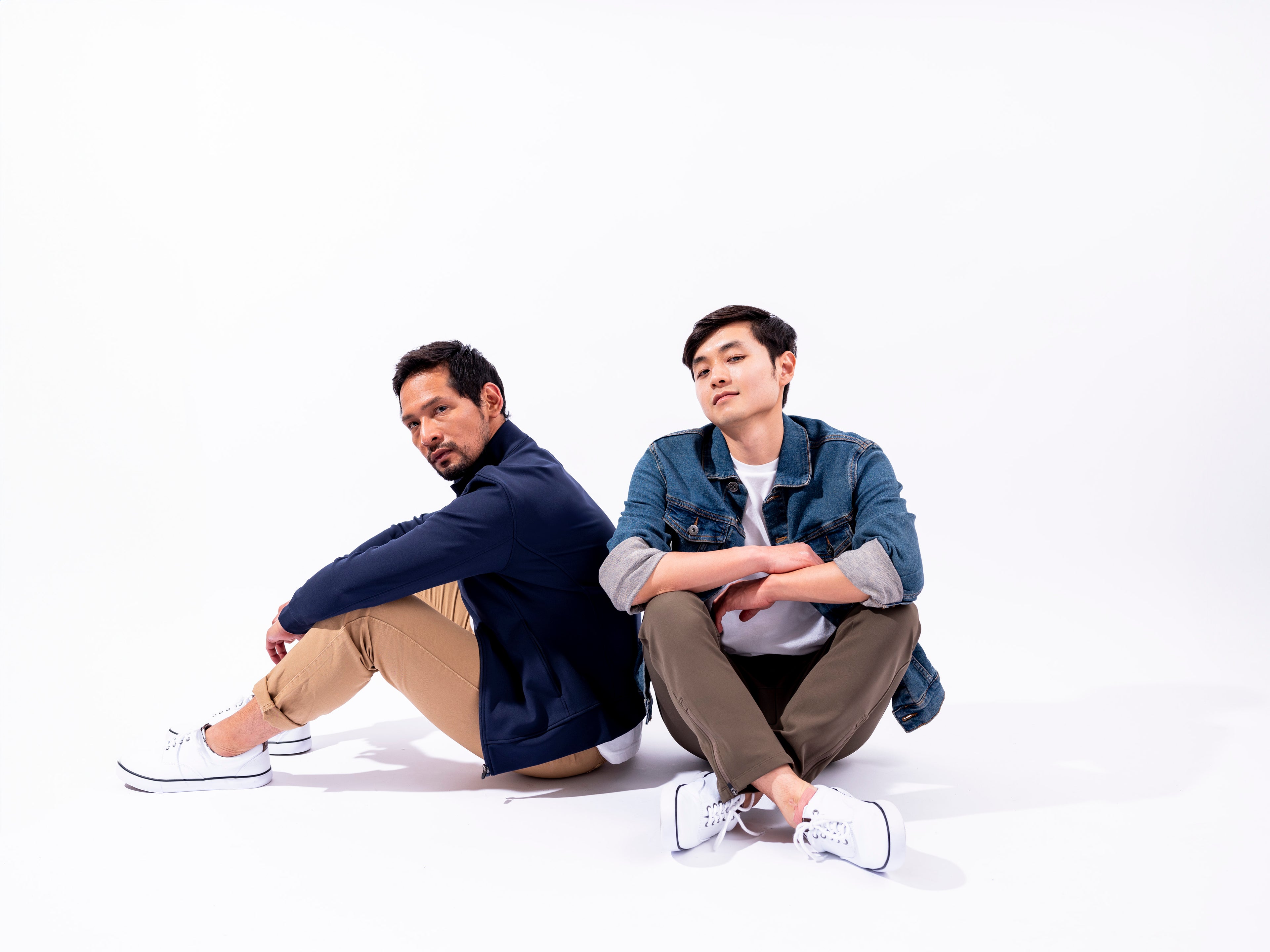 Two men sitting in front of white wall wearing the Andy Joggers and Hunter Jacket