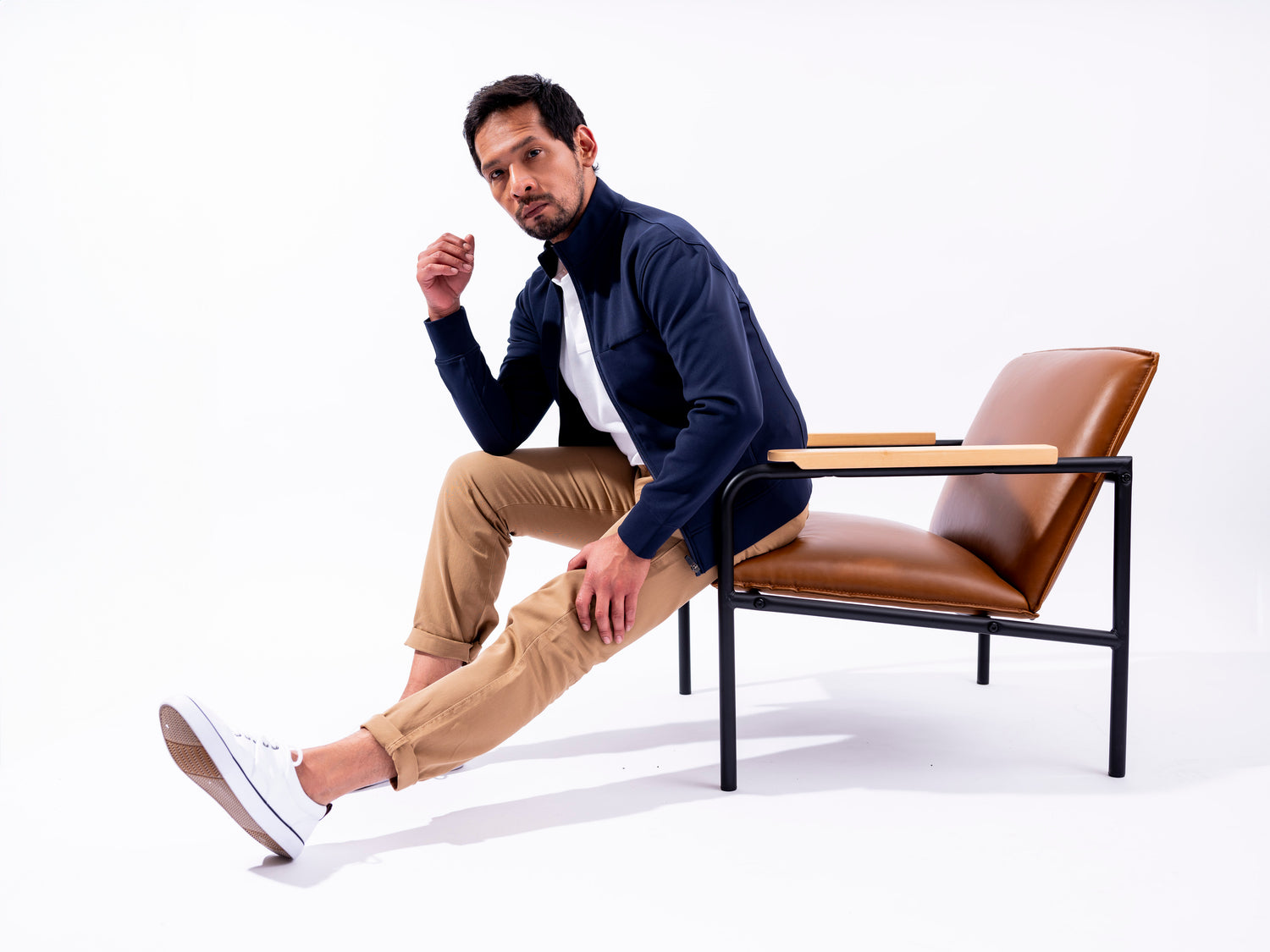 Man sitting on chair in white room wearing the Hunter Jacket